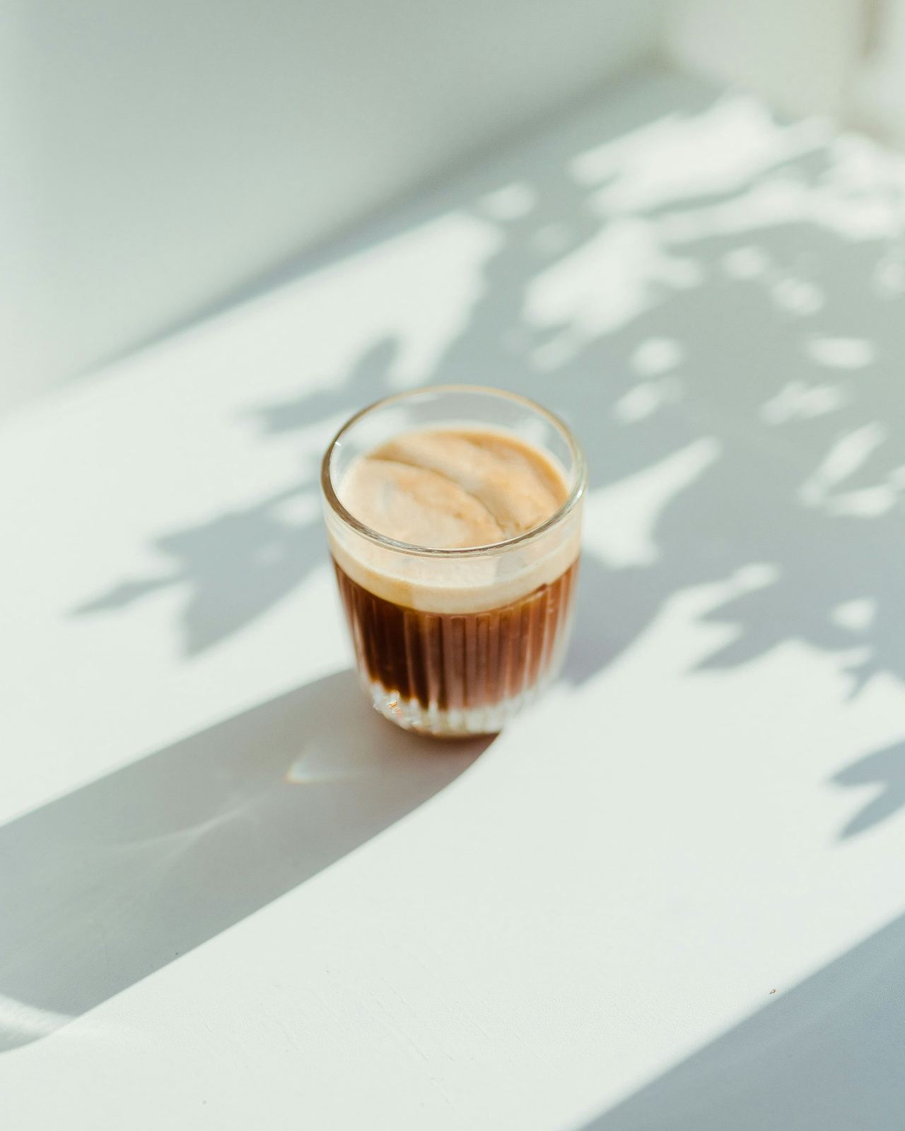 A cortado in a glass, in the morning sun