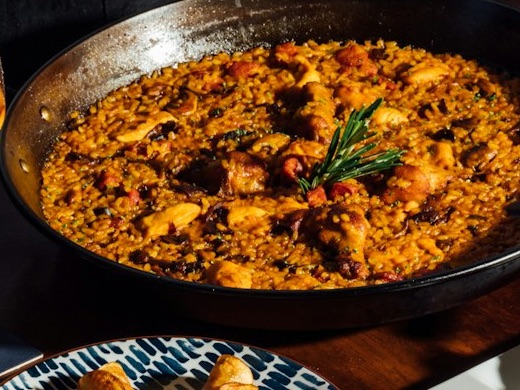 A freshly made paella with a sprig of rosemary on top