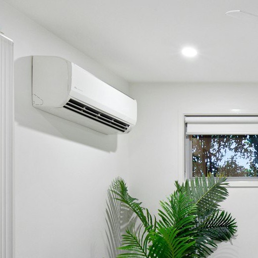 White split unit on a living room wall, up by the ceiling