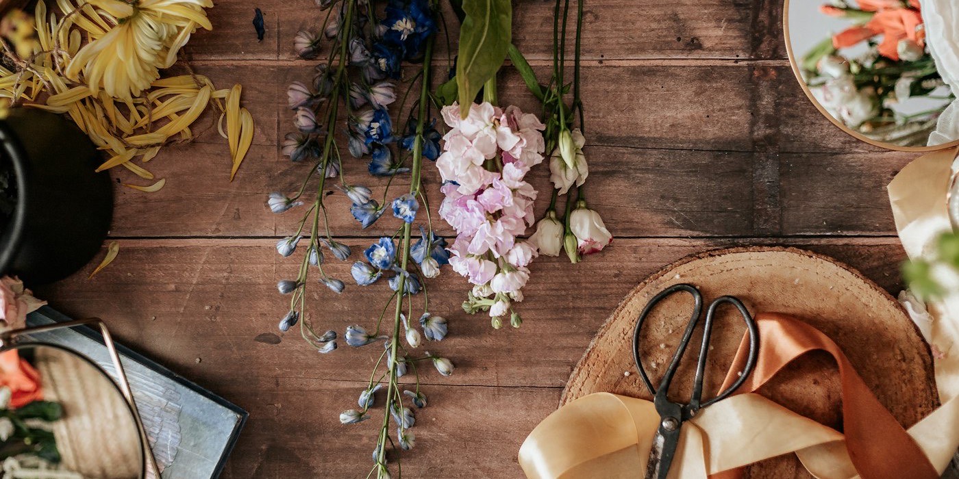 Flor cortada, tijeras y cinta sobre la mesa de trabajo