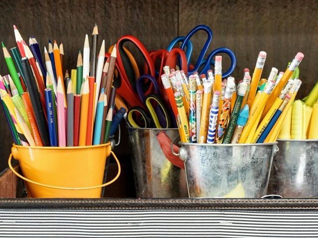 Colouring pencils, graphite pencils and scissors in metal pots
