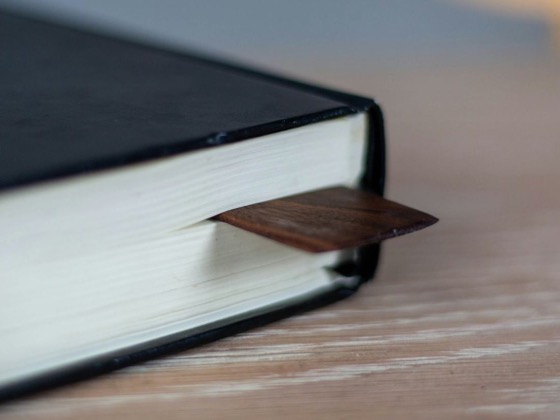 Corner of a black hardback book with a wooden bookmark