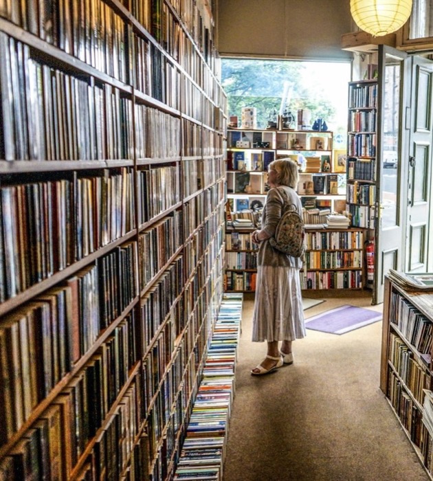 Прохід у книгарні між стелажами, повними книжок