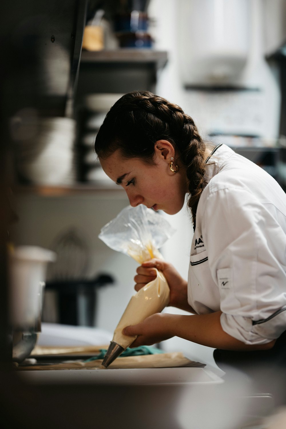 Daria, pastelera, decorando con una manga pastelera en una cocina profesional