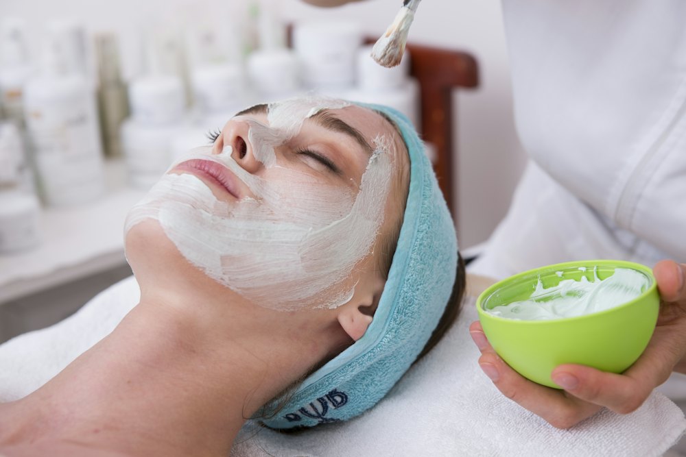 Mascarilla facial con la clienta tumbada en la camilla